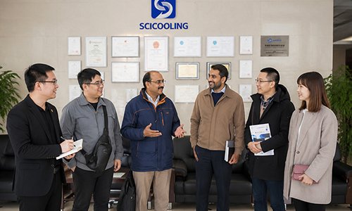 Pakistani clients and SCICOOLING staff standing together for a group photo in the company lobby.