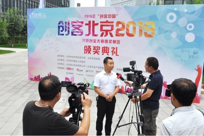 A SCICOOLING representative being interviewed by media during the Maker Beijing 2019 event.