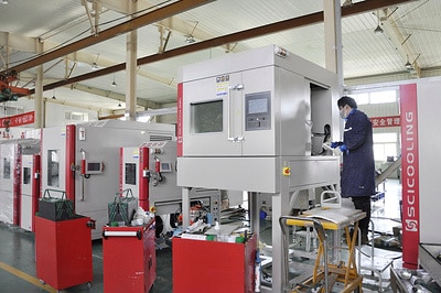 Technician commissioning a large SCI chamber on the factory floor