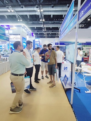 SCICOOLING staff speaking with visitors beside exhibition displays