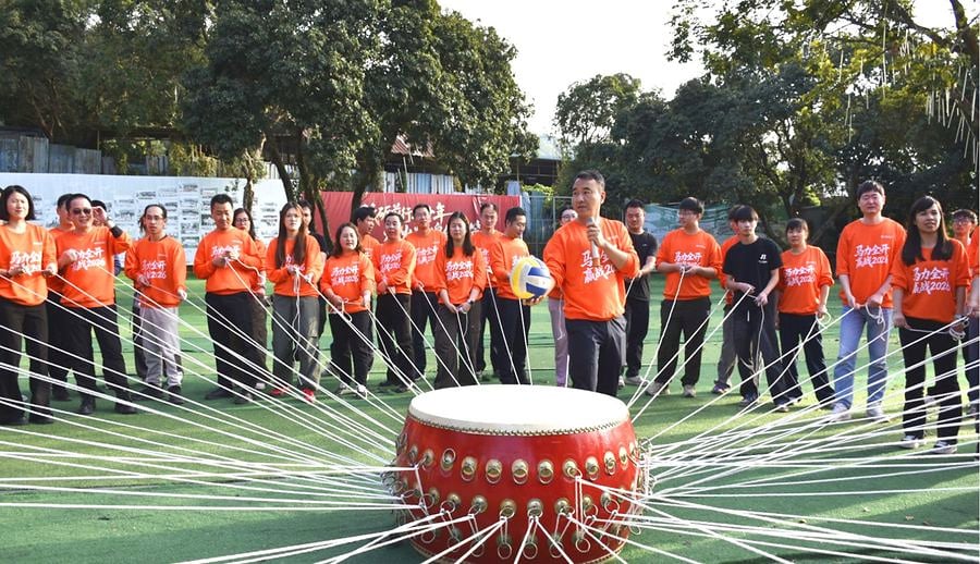 SCICOOLING employees completing an outdoor team drum challenge